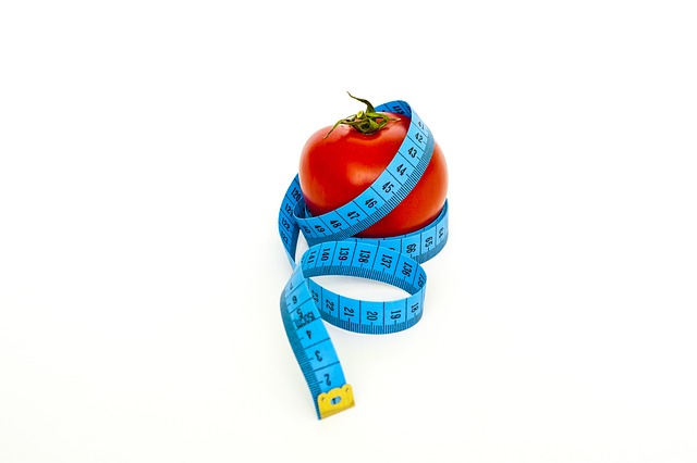 A tomatoe with a tape measure around it