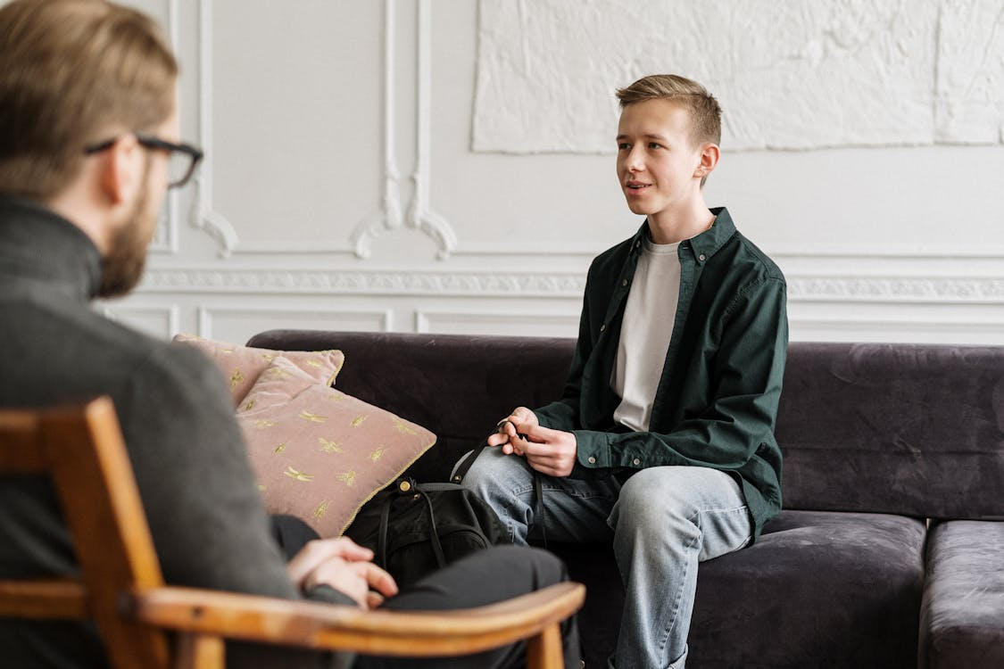 Man talking to a boy in therapy session